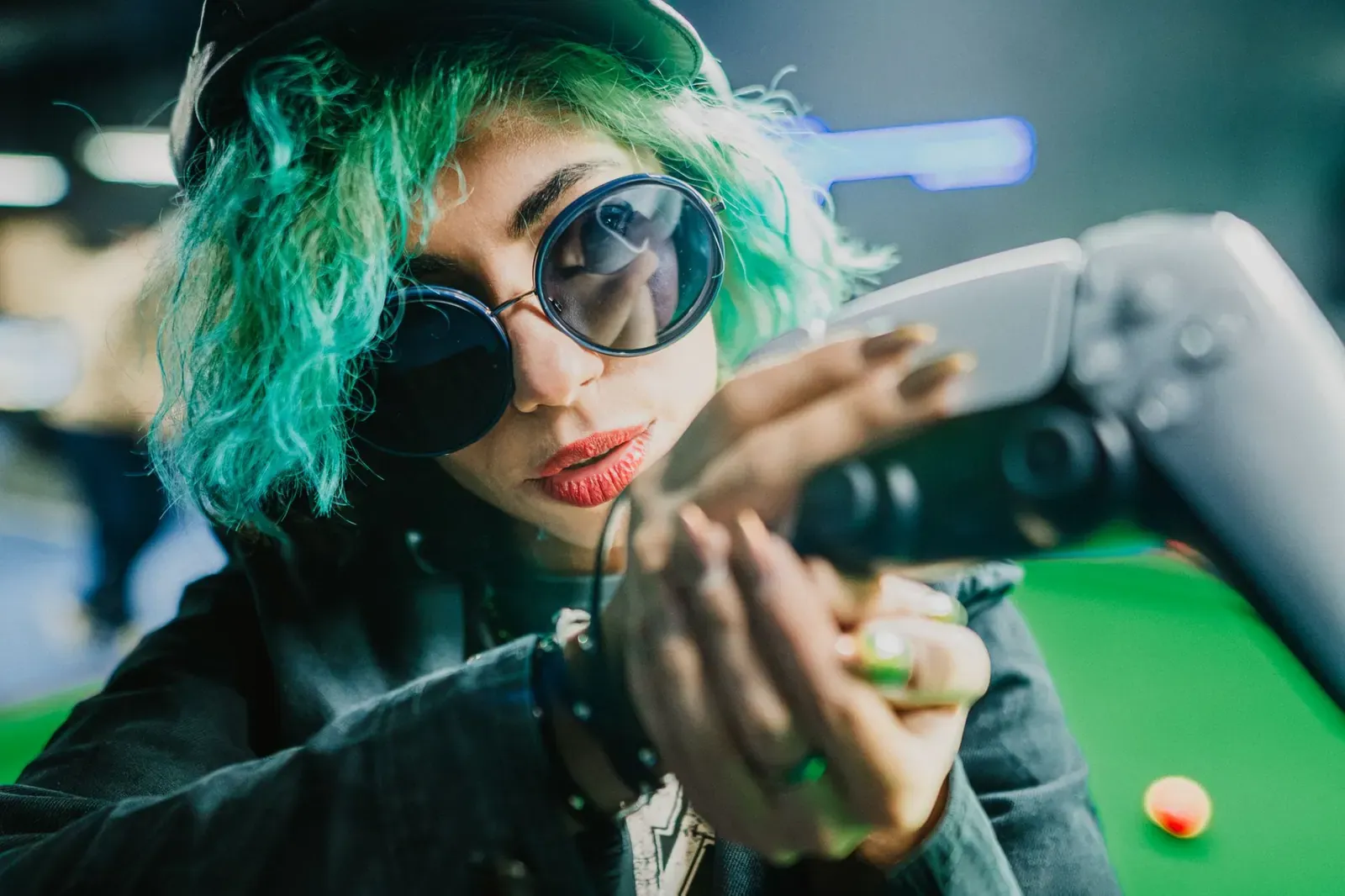 Femme audacieuse aux cheveux verts et lunettes de soleil jouant à la réalité virtuelle dans un pub vibrant