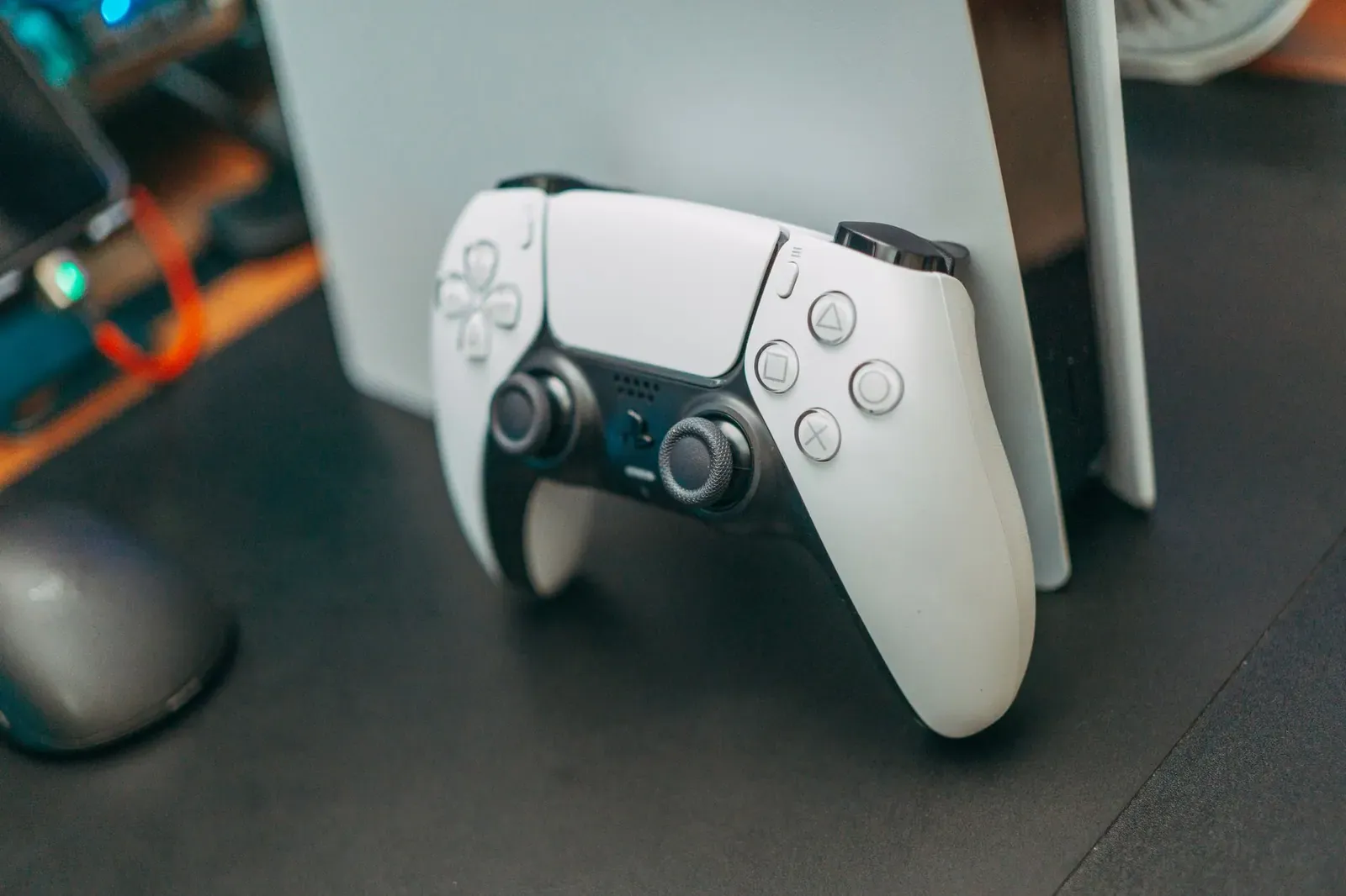 Une manette de console posée à côté de la console, sur un bureau