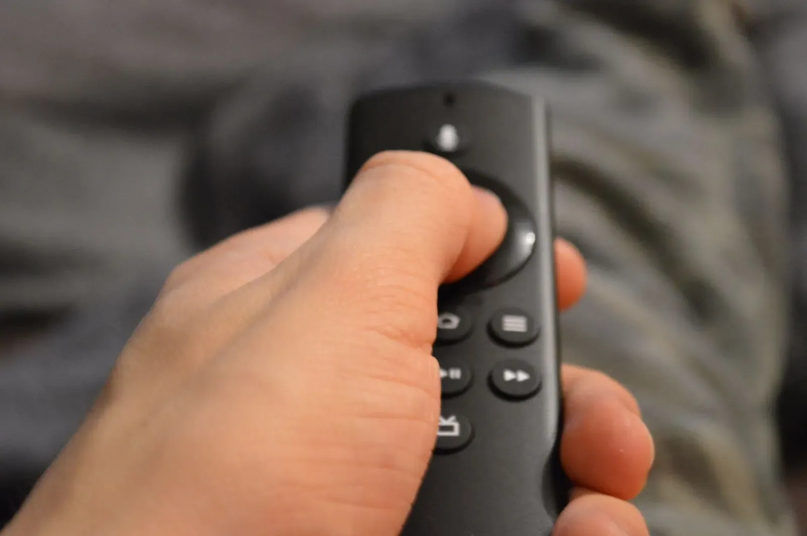Une main tient une télécommande de clé de streaming