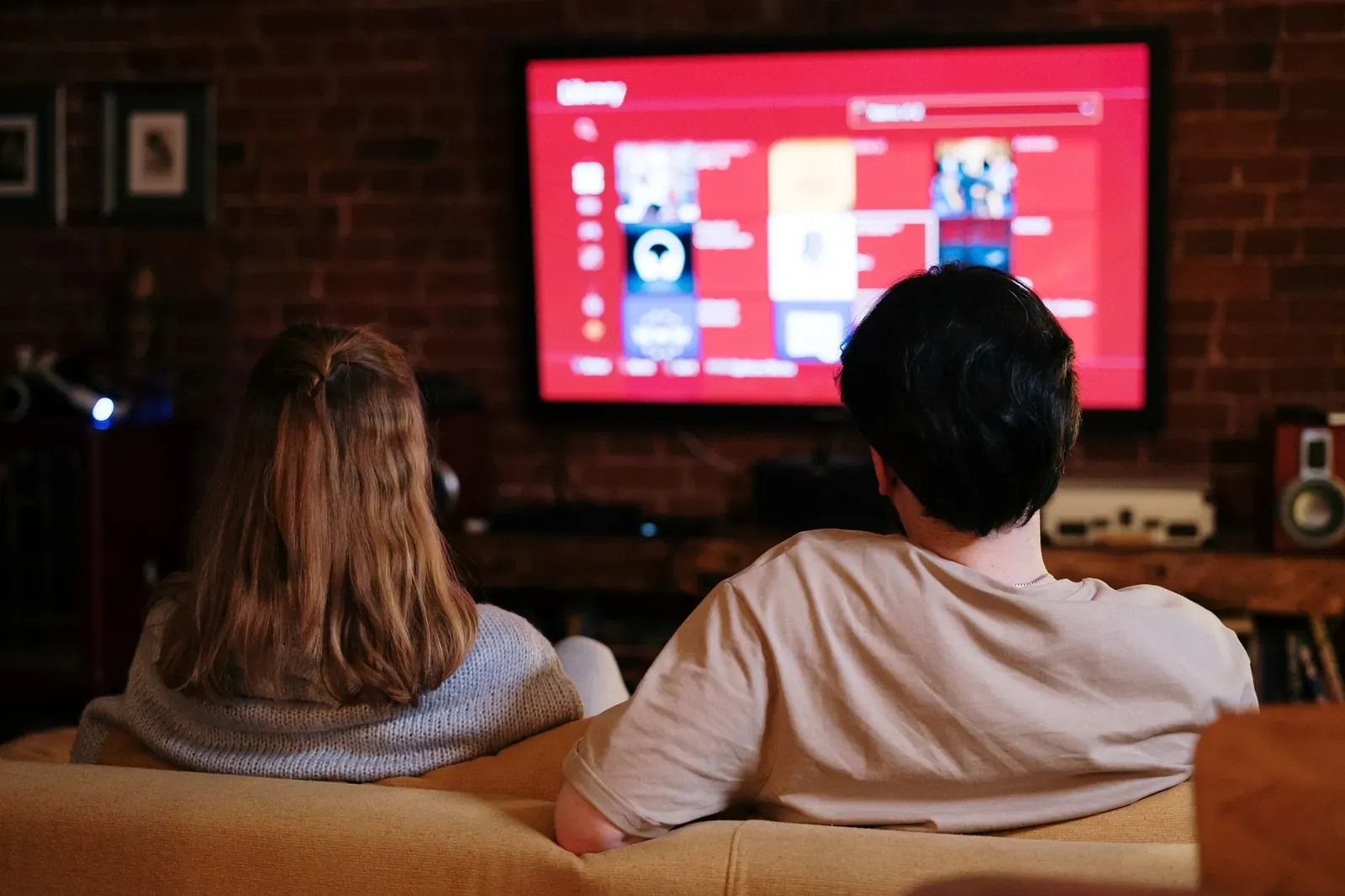 Un couple profite de diffuser des émissions sur un grand téléviseur dans un salon chaleureux aux murs en